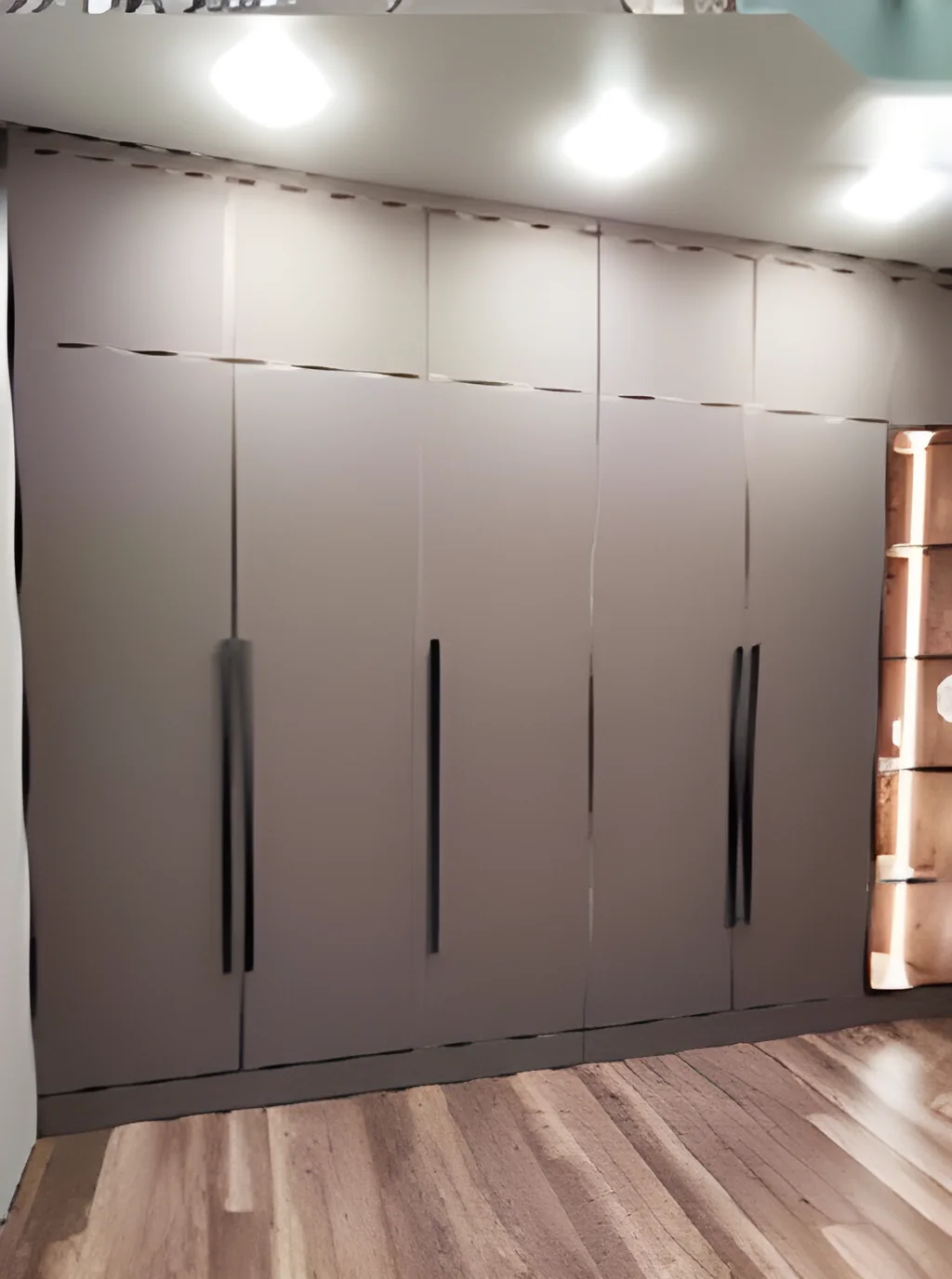 Floor-to-ceiling wardrobe run in warm taupe with slim inset black pulls